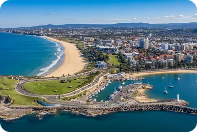 Aerial view of Wollongong Harbour and North Beach, New South Wales, showcasing the coastline, marina, city skyline, and scenic oceanfront.