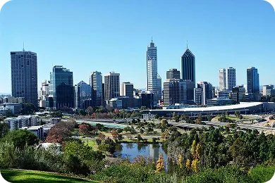 Perth city skyline, Western Australia, featuring the CBD skyscrapers, Riverside Drive, and surrounding parklands under a clear blue sky.